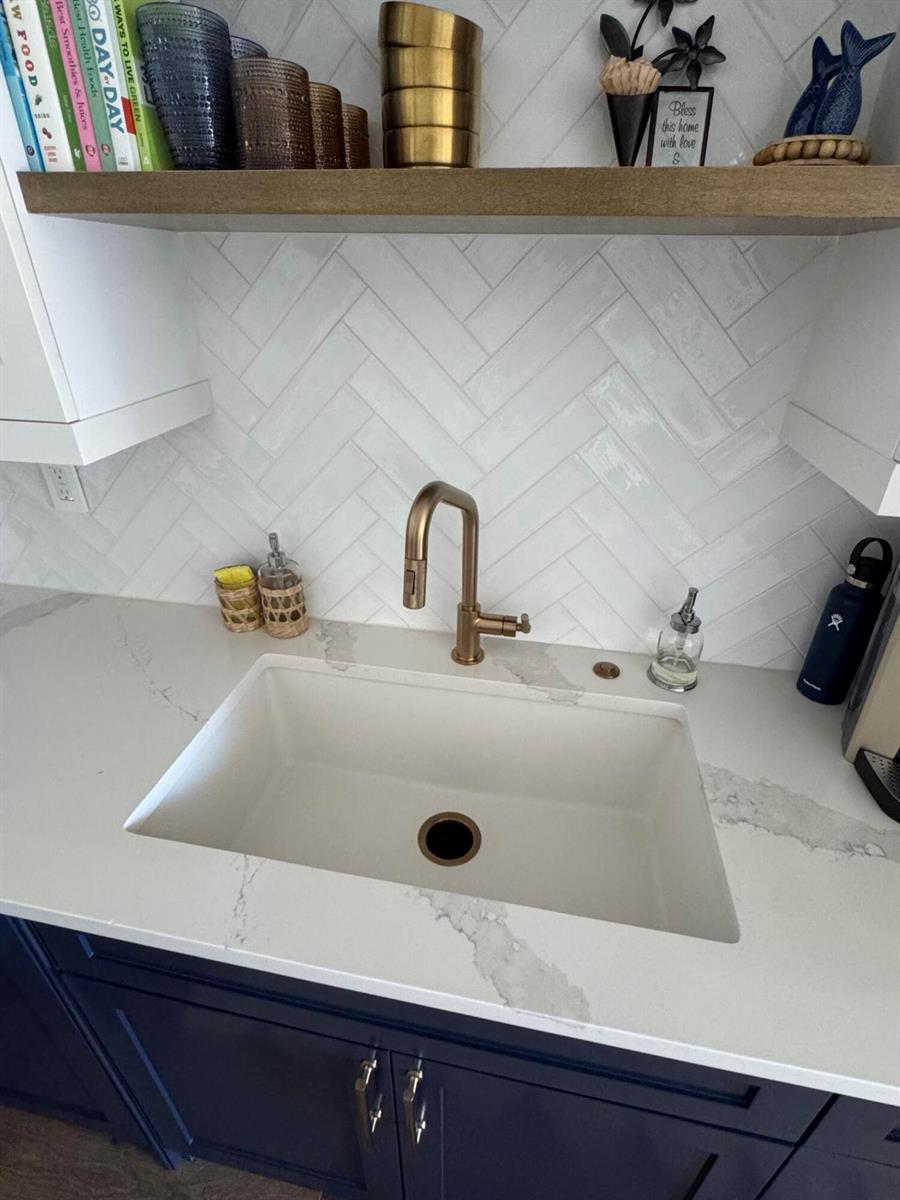 A kitchen sink area features a white farmhouse sink, gold faucet, and herringbone tile backsplash — 2545 S Ocean Boulevard # 3140, Palm Beach FL 33480, PALM BEACH, FL