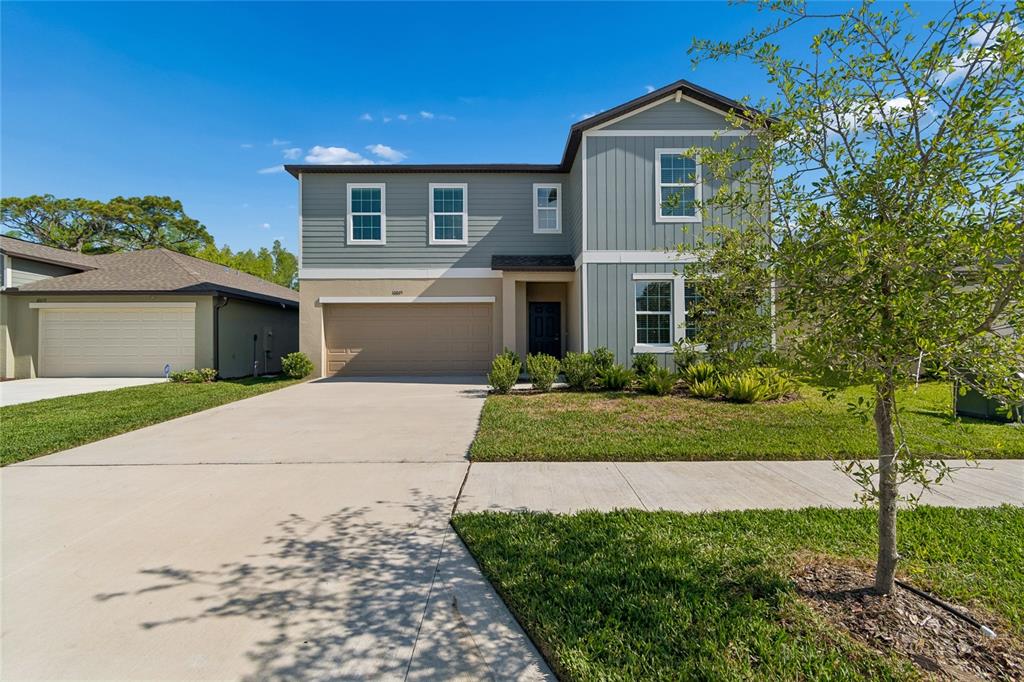 A two-story house with a gray exterior, a two-car garage, and a concrete driveway — 10065 GENTLE RAIN DRIVE, LAND O LAKES, FL