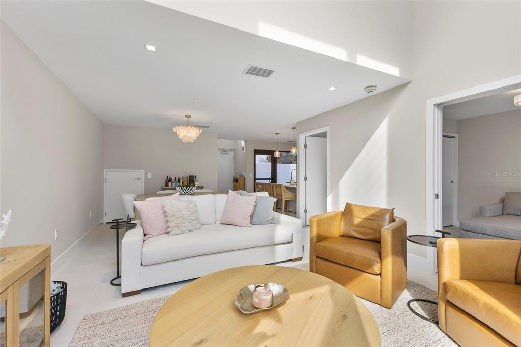 A living room features a white sofa, two leather armchairs, and a round wooden coffee table — 1558 4TH ST UNIT 212, SARASOTA, FL