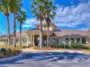 A tan commercial building with a portico entrance stands behind a parking lot with palm trees — 1169 EMERALD HILL WAY, VALRICO, FL