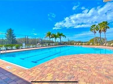 A large rectangular swimming pool with lane markers is surrounded by a brick paver deck — 1169 EMERALD HILL WAY, VALRICO, FL