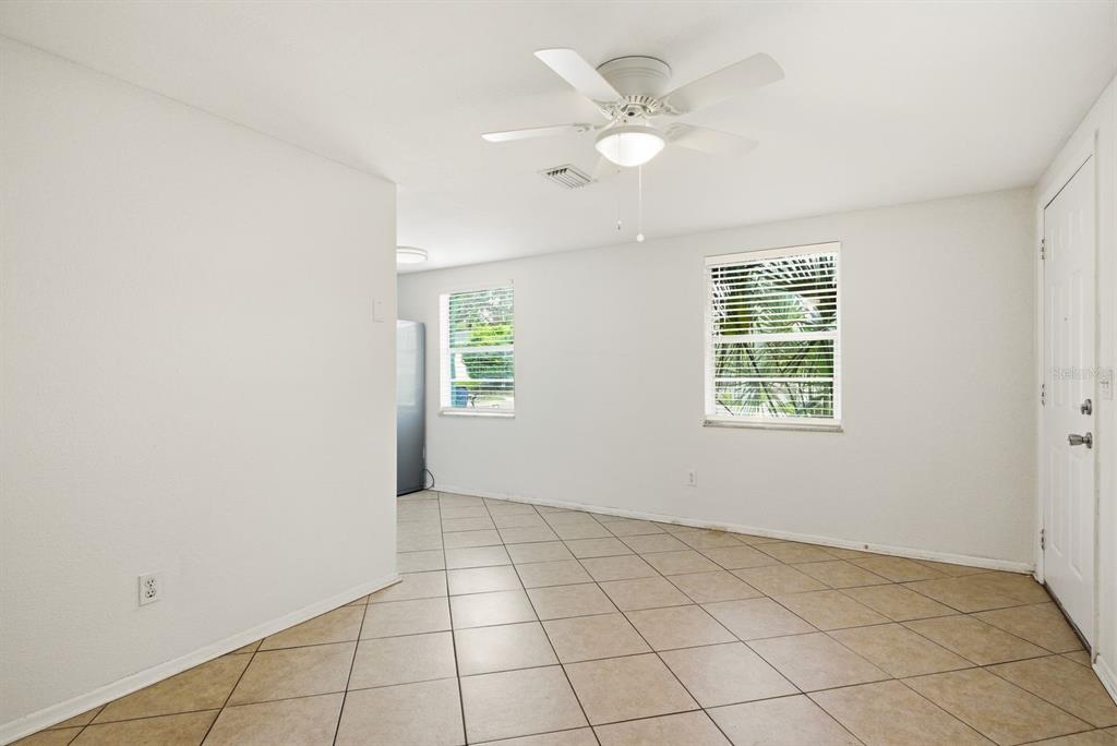 A room with white walls, a ceiling fan, tiled floors, and two windows — 417 MILWAUKEE AVENUE, DUNEDIN, FL