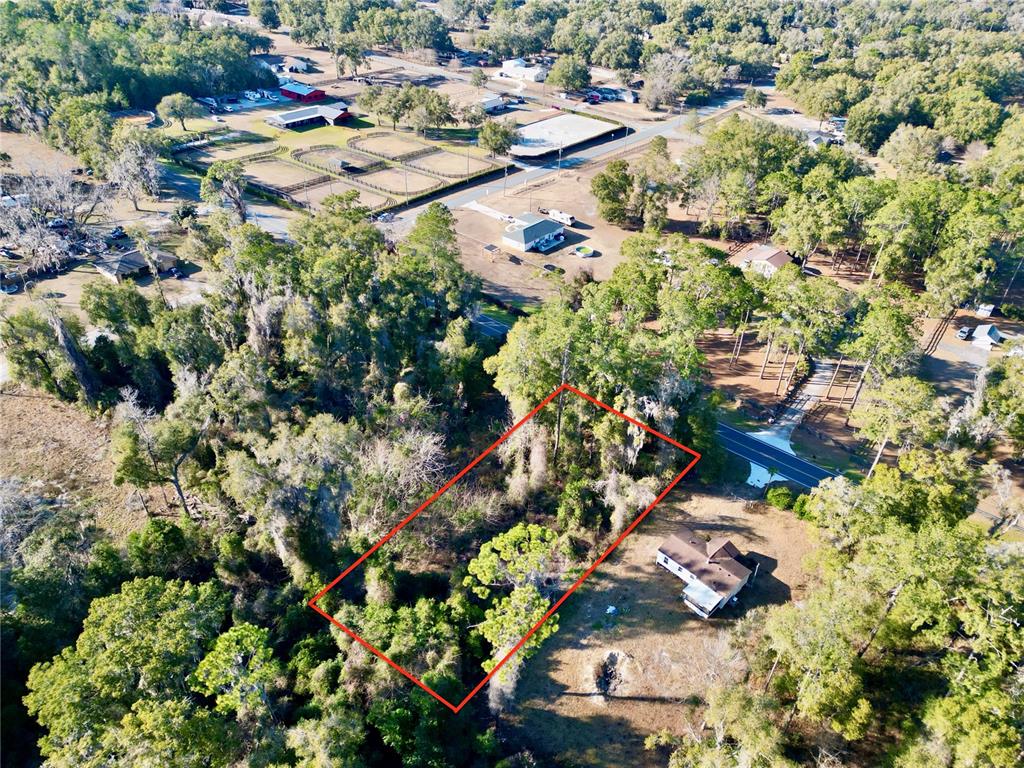 An aerial view shows a rectangular wooded lot outlined in red next to a house — TBD W HWY 328, OCALA, FL
