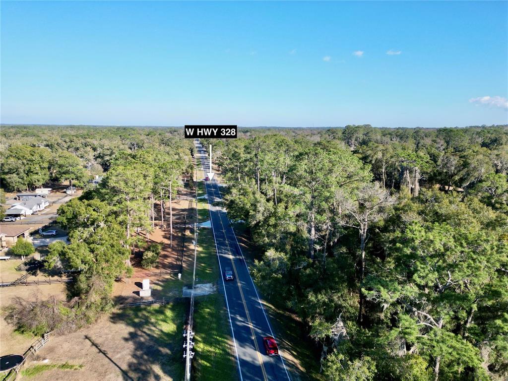 An aerial view shows a two-lane road running through a dense, wooded area — TBD W HWY 328, OCALA, FL