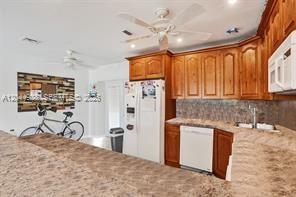 A kitchen features wood cabinets, a white refrigerator, a dishwasher, and a ceiling fan — 1061 NE 26th Ave # 1061, Pompano Beach FL 33062, POMPANO BEACH, FL