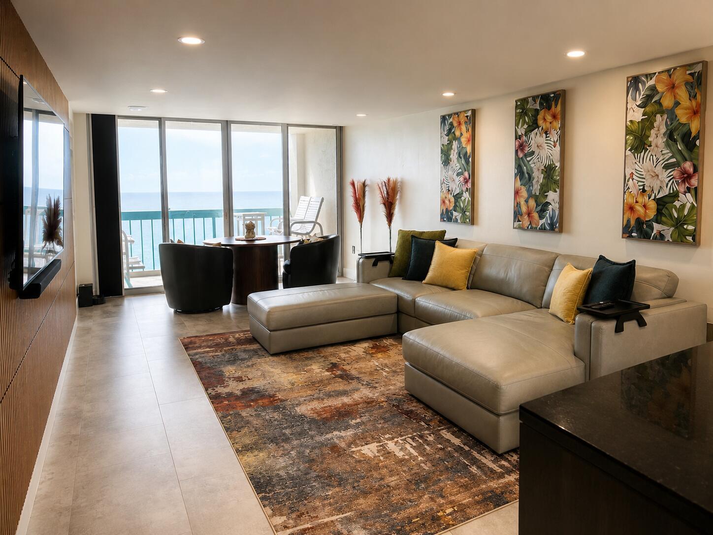 A living room with a gray sectional, patterned rug, and a balcony overlooking the ocean — 9940 S Ocean Drive # 802, Jensen Beach FL 34957, JENSEN BEACH, FL