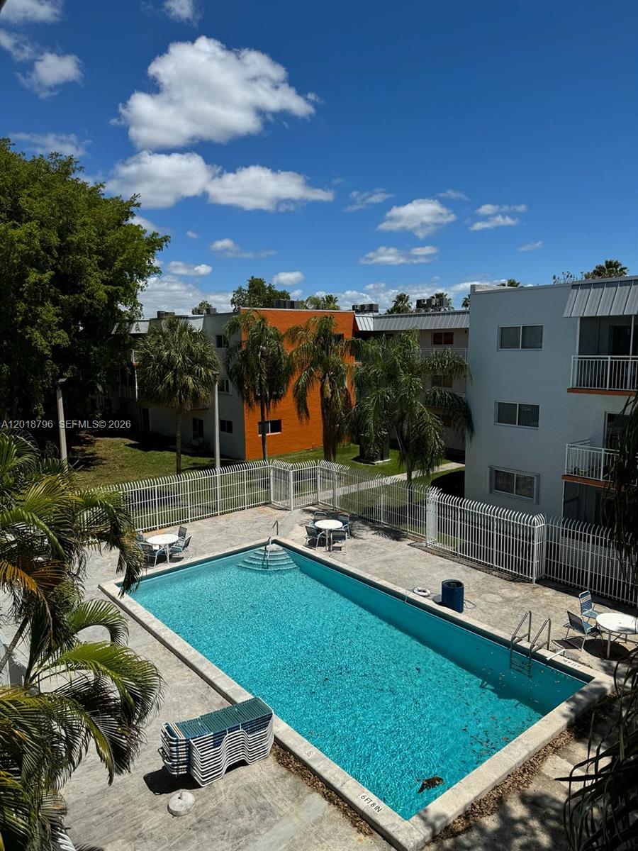 An outdoor swimming pool is surrounded by a concrete deck, lounge chairs, and apartment buildings — 11307 SW 200th St # B, Miami FL 33157, MIAMI, FL