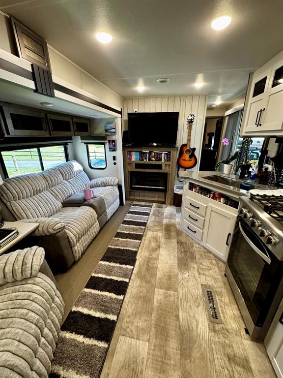 A living room and kitchen area in a recreational vehicle featuring a sofa and fireplace — 14423 NE 252ND COURT ROAD, SALT SPRINGS, FL