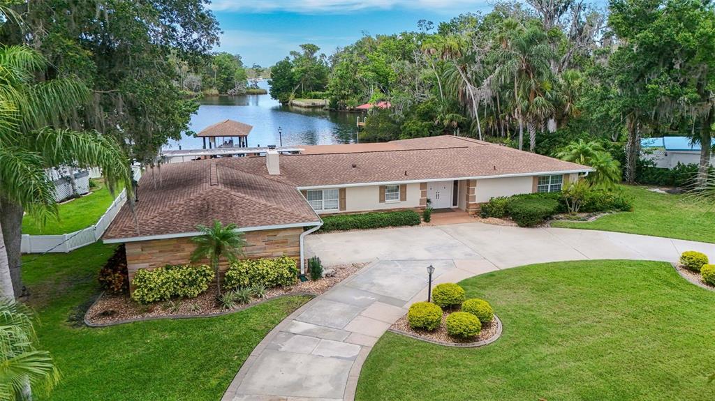 An aerial view of a single-story house with a brown roof, stone siding, and waterfront access — 1202 SE KINGS BAY DRIVE, CRYSTAL RIVER, FL