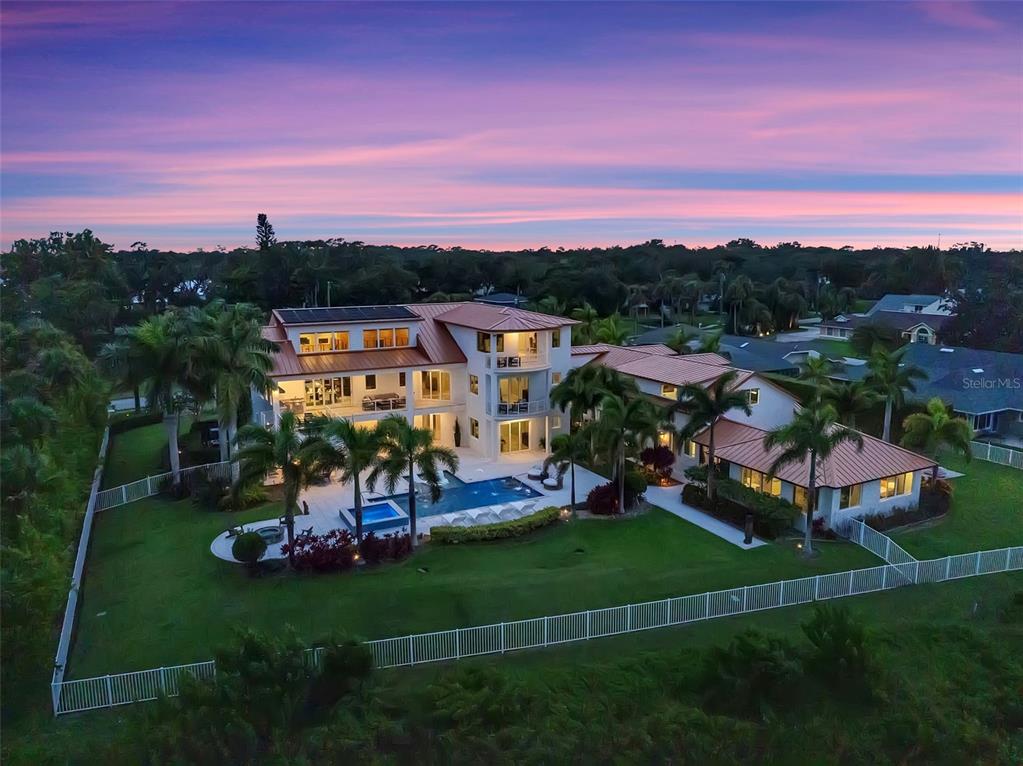 An aerial view of a large multi-story house with a pool, palm trees, and lawn — 1511 S RIVERSIDE DRIVE, NEW SMYRNA BEACH, FL
