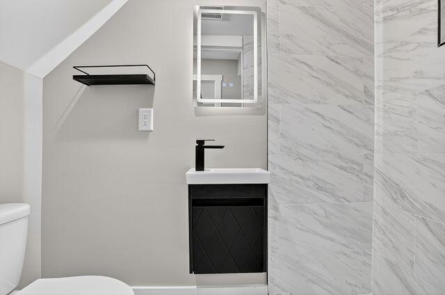 A modern bathroom features a floating vanity, a lighted mirror, and white marble-look wall tiles — 3241 Turner Street # 10, FL 32222, FL