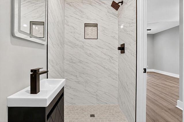 A modern bathroom features a floating vanity, a walk-in shower with marble-look tile, and fixtures — 3241 Turner Street # 10, FL 32222, FL