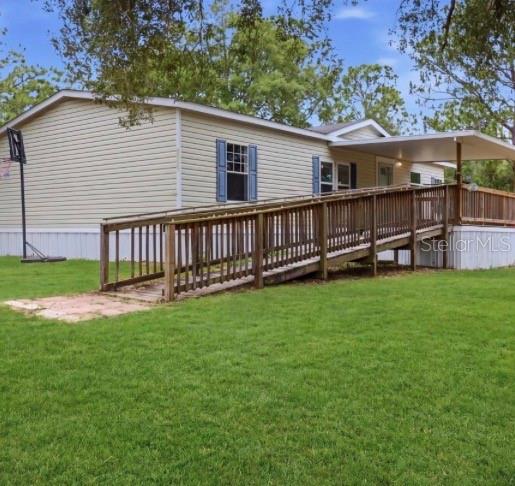 A single-story mobile home with beige siding features a wooden wheelchair ramp leading to a deck — 4524 SW 162ND TERRACE, OCALA, FL