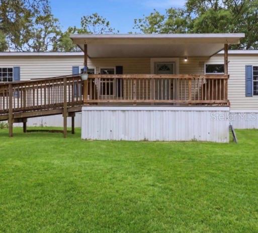 A mobile home exterior featuring a wooden deck with a ramp and a covered porch — 4524 SW 162ND TERRACE, OCALA, FL