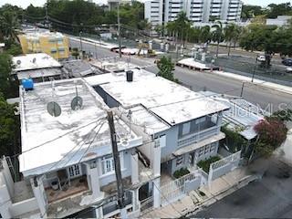 An aerial view shows the flat roofs of two adjacent residential buildings near a street — 1006 JOSE GANDARA UNIT 6, SAN JUAN, PR
