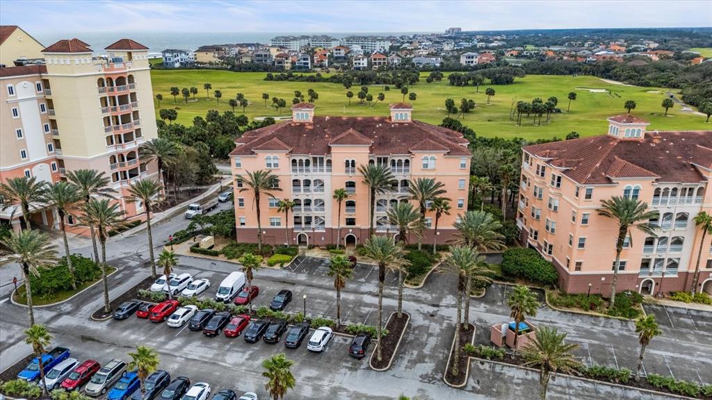An aerial view shows three multi-story apartment buildings with parking lots and a golf course — 5 OCEAN CREST WAY UNIT 1414, PALM COAST, FL