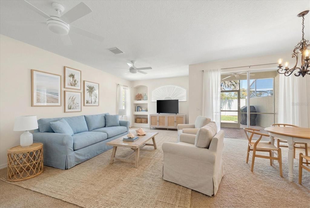 A living room features a blue sofa, two armchairs, a coffee table, and a dining area — 1620 RACHEL COURT, CLEARWATER, FL