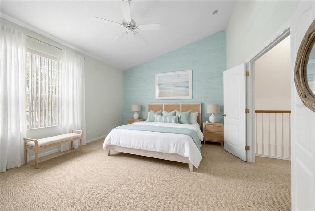 A bedroom features a light blue shiplap accent wall, a bed, and beige carpeting — 1620 RACHEL COURT, CLEARWATER, FL
