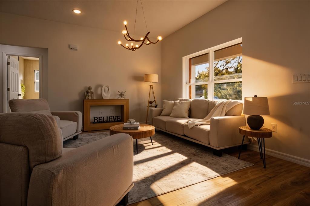 A living room features a beige sofa, two armchairs, a wooden coffee table, and chandelier — 2116 W BEACH PLUM DRIVE, CITRUS SPRINGS, FL