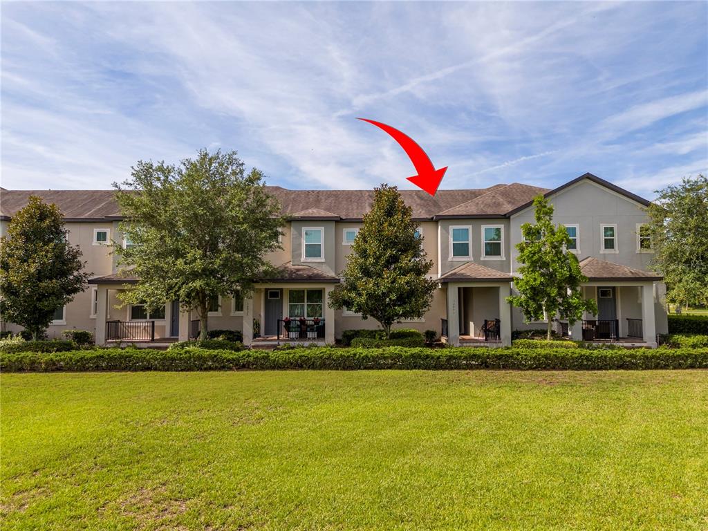 A row of two-story townhomes with beige stucco exteriors and a shared shingled roof — 14031 PICARD ALLEY, WINTER GARDEN, FL
