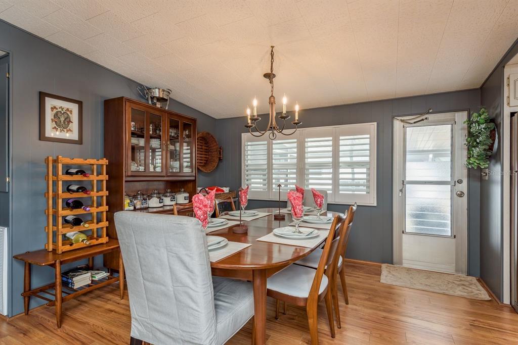 A dining room features a wooden table, upholstered chairs, a hutch, and dark gray walls — 2331 BELLEAIR ROAD UNIT 906, CLEARWATER, FL