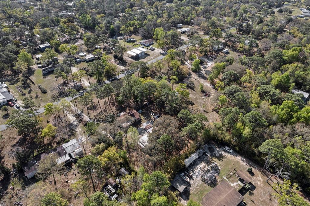 An aerial view shows several houses and outbuildings scattered among dense trees and dirt roads — 6850 S MAXWELL POINT, HOMOSASSA, FL