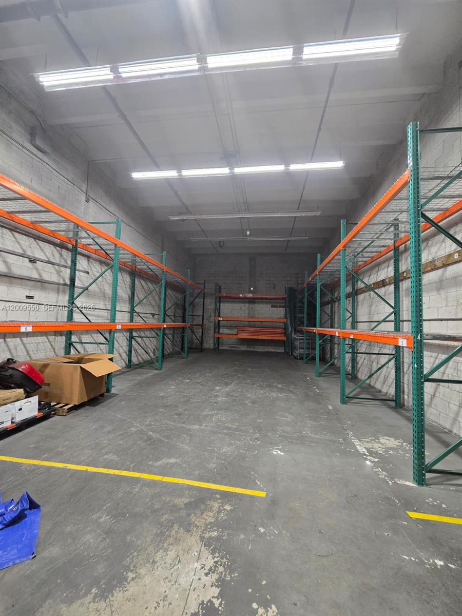 An industrial warehouse space features tall metal storage racks along both side walls — 7953 NW 64th St, Medley FL 33166, MEDLEY, FL