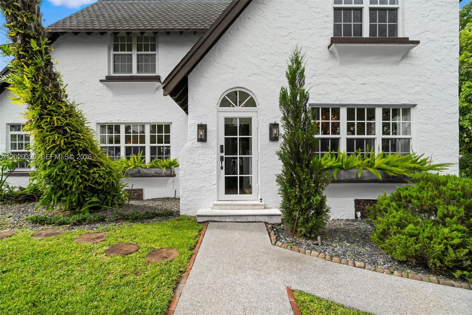 A white stucco house features a front door with a transom window and window boxes — 646 NE 81st St, Miami FL 33138, MIAMI, FL