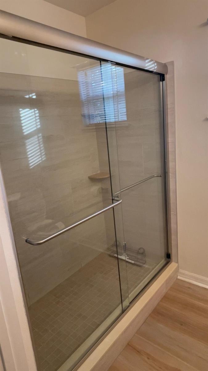 A walk-in shower with glass sliding doors and light-colored tile walls — 426 Easy Street, Sebastian FL 32958, SEBASTIAN, FL