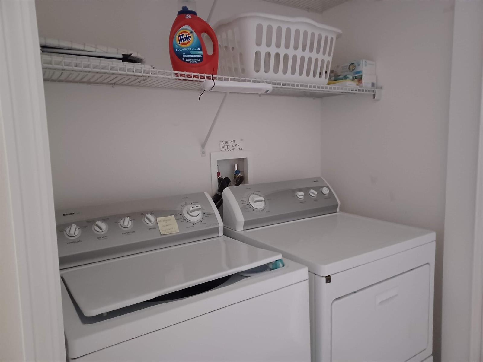 A laundry closet features a white top-load washer, a dryer, and a wire storage shelf — 426 Easy Street, Sebastian FL 32958, SEBASTIAN, FL