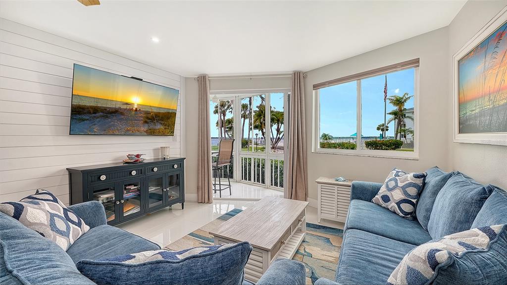 A living room with blue sofas, a shiplap wall, and a view of the outdoors — 771 JOHN RINGLING BOULEVARD UNIT 5, SARASOTA, FL