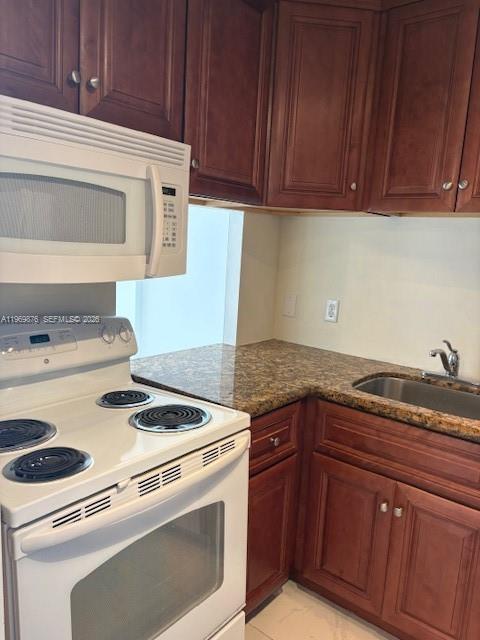 A kitchen features wood cabinets, a white electric stove, a microwave, and granite countertops — 3181 S Ocean Dr # 304, Hallandale Beach FL 33009, HALLANDALE BEACH, FL