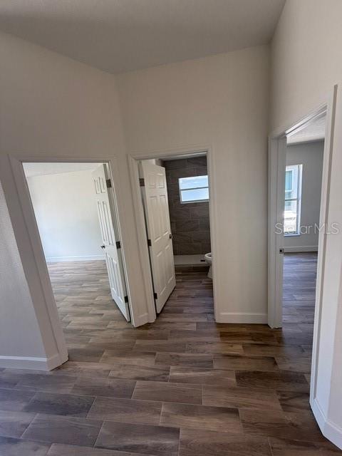 A hallway with wood-look tile flooring leads to two bedrooms and a bathroom — 108 SUNDANCE COURT, WINTER SPRINGS, FL