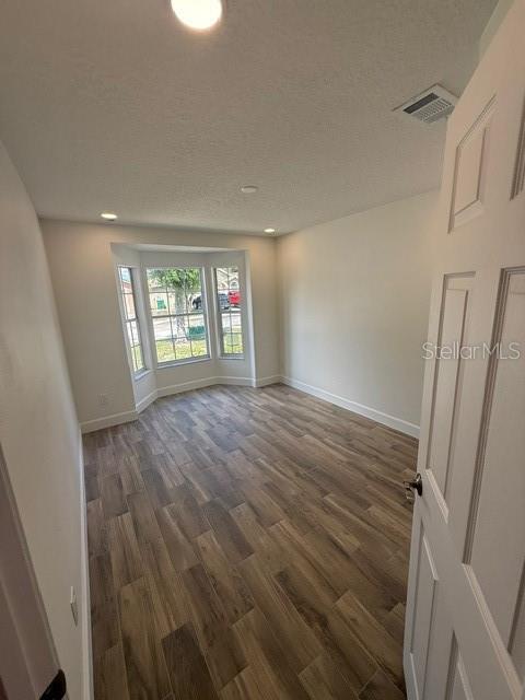 An empty bedroom features light wood-look flooring, recessed lighting, and a large bay window — 108 SUNDANCE COURT, WINTER SPRINGS, FL