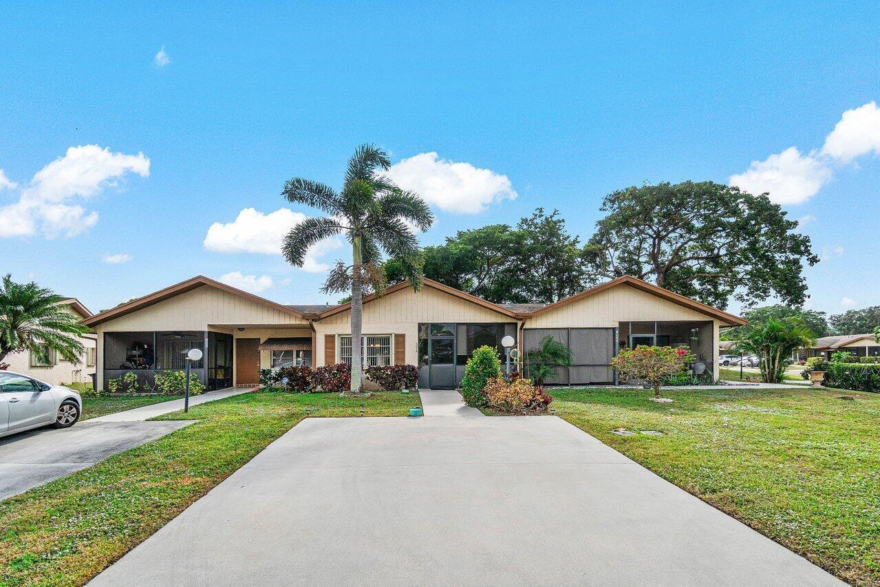 A single-story house with a concrete driveway, a palm tree, and screened-in porches — 5814 Doris Court, Delray Beach FL 33484, DELRAY BEACH, FL