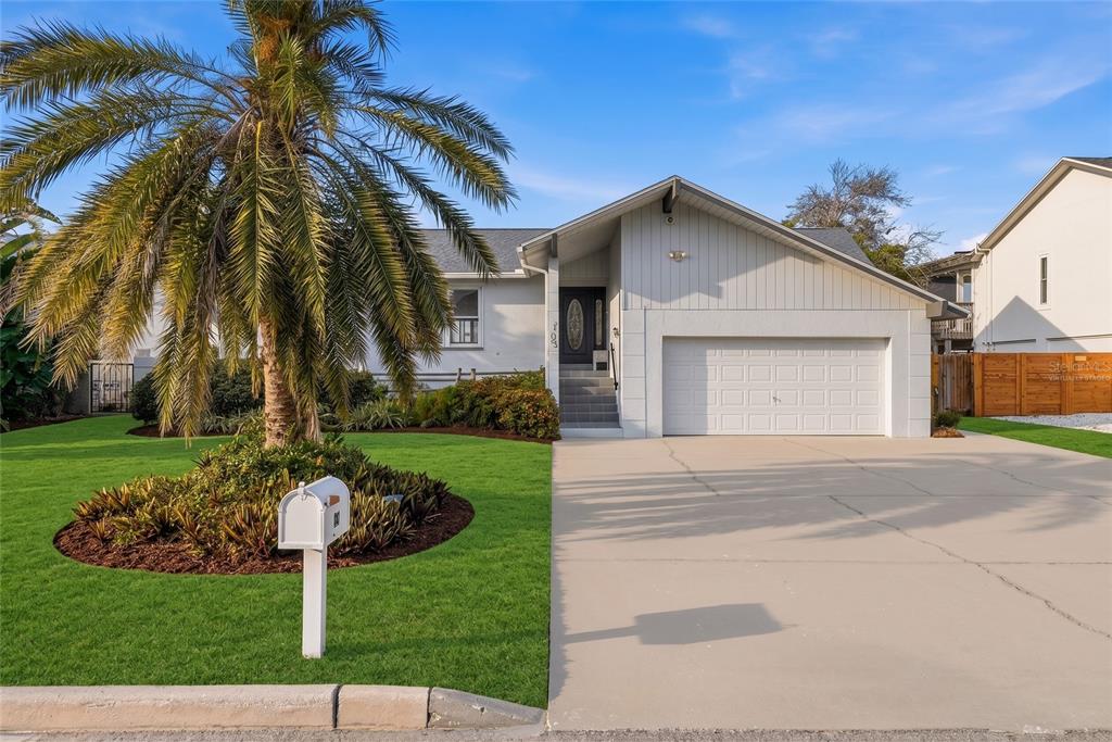 A single-story house with a white garage, a palm tree, and a front lawn — 155 1ST STREET W, TIERRA VERDE, FL