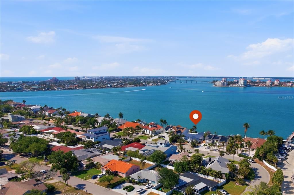 An aerial view shows waterfront homes along a bay with a bridge in the distance — 155 1ST STREET W, TIERRA VERDE, FL