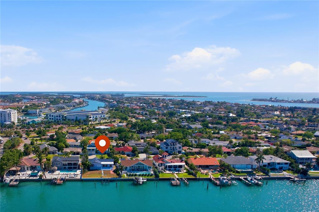 An aerial view shows a waterfront residential neighborhood with a marked house along the canal — 155 1ST STREET W, TIERRA VERDE, FL