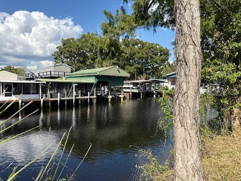 A view of boat docks and covered slips along a canal with surrounding trees — 71 SE 893 AVENUE, OLD TOWN, FL