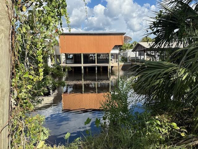 A raised orange metal structure sits above a canal surrounded by lush green vegetation — 71 SE 893 AVENUE, OLD TOWN, FL