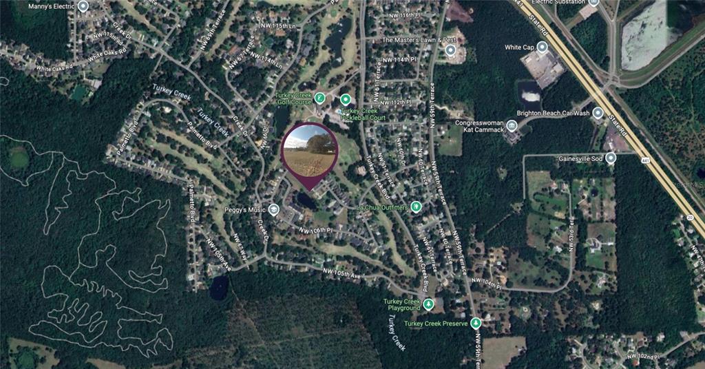 This is a satellite map view of a residential neighborhood with a circular photo overlay — NW 109TH PLACE, ALACHUA, FL