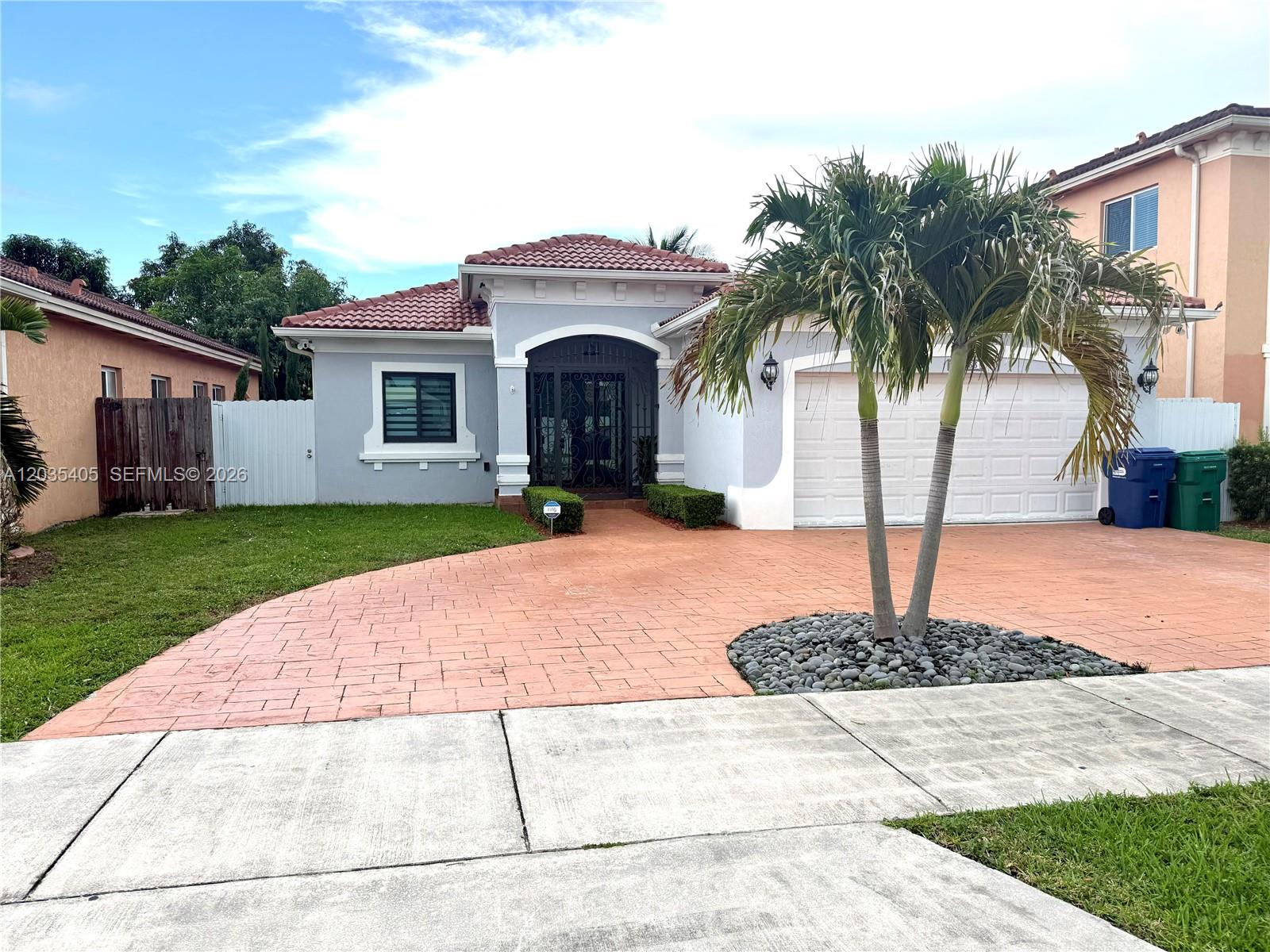 A single-story house with a gray exterior, red tile roof, and a paved driveway — 17833 SW 155th Ct, Miami FL 33187, MIAMI, FL