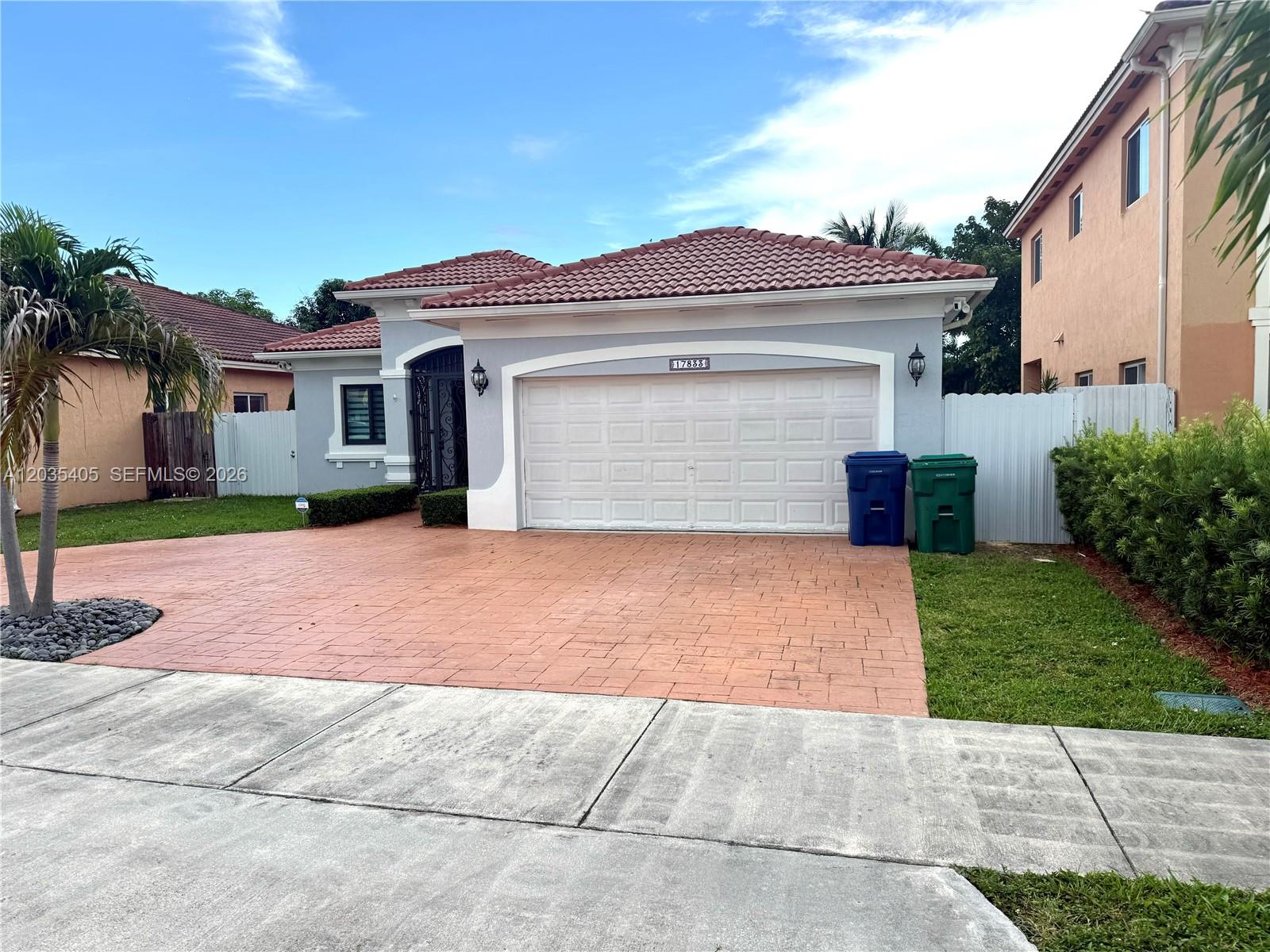 A single-story house with a tiled roof, gray exterior, and a paved driveway — 17833 SW 155th Ct, Miami FL 33187, MIAMI, FL