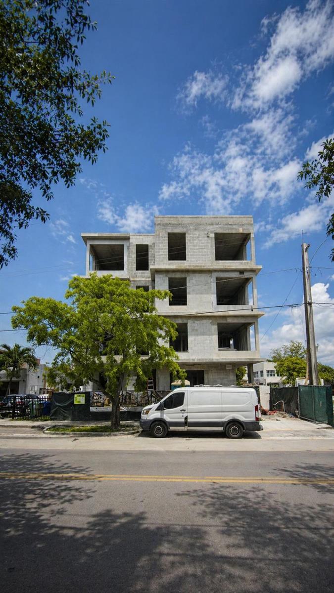 A four-story concrete building under construction stands behind a white van on a street — 259 NW 33rd Street # 2, Miami FL 33127, MIAMI, FL