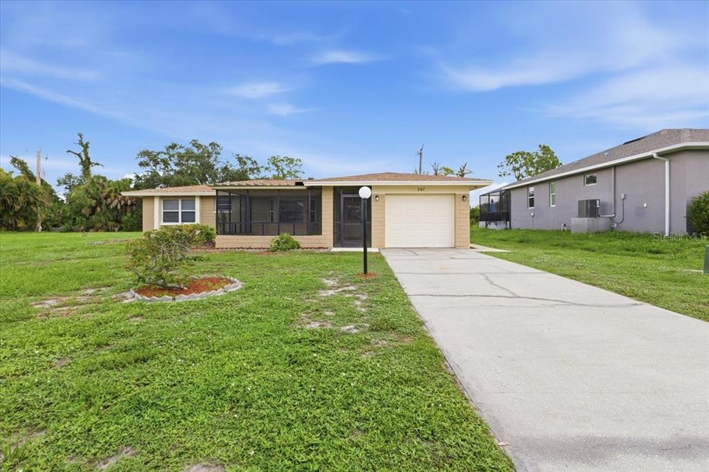 A single-story house with a screened porch, a garage, and a concrete driveway — 267 ANNAPOLIS LANE, ROTONDA WEST, FL