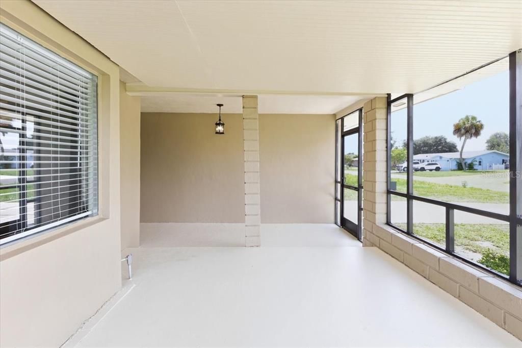 A covered patio with a concrete floor, block walls, and a screened-in exterior view — 267 ANNAPOLIS LANE, ROTONDA WEST, FL