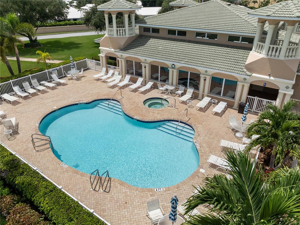 An aerial view of a swimming pool and hot tub on a brick patio — 6616 7TH AVENUE CIRCLE W UNIT 1311, BRADENTON, FL