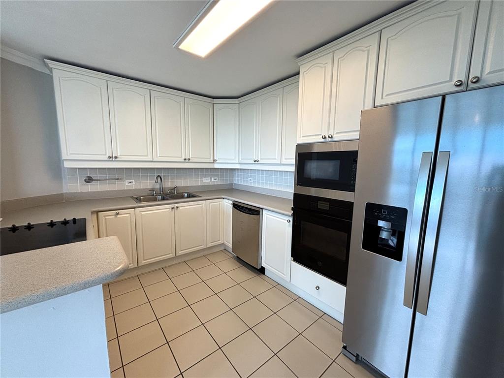 A kitchen with white cabinets, stainless steel appliances, tile flooring, and a peninsula counter — 550 Avenida Constitucion AVENIDA CONSTITUCION UNIT 901, SAN JUAN, PR