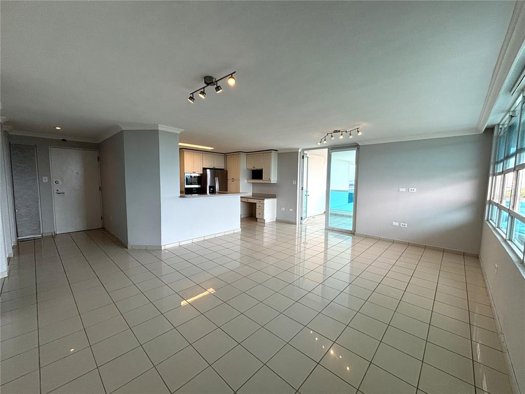 An open-concept living area features light-colored tile flooring, a kitchen with white cabinetry, and a balcony — 550 Avenida Constitucion AVENIDA CONSTITUCION UNIT 901, SAN JUAN, PR