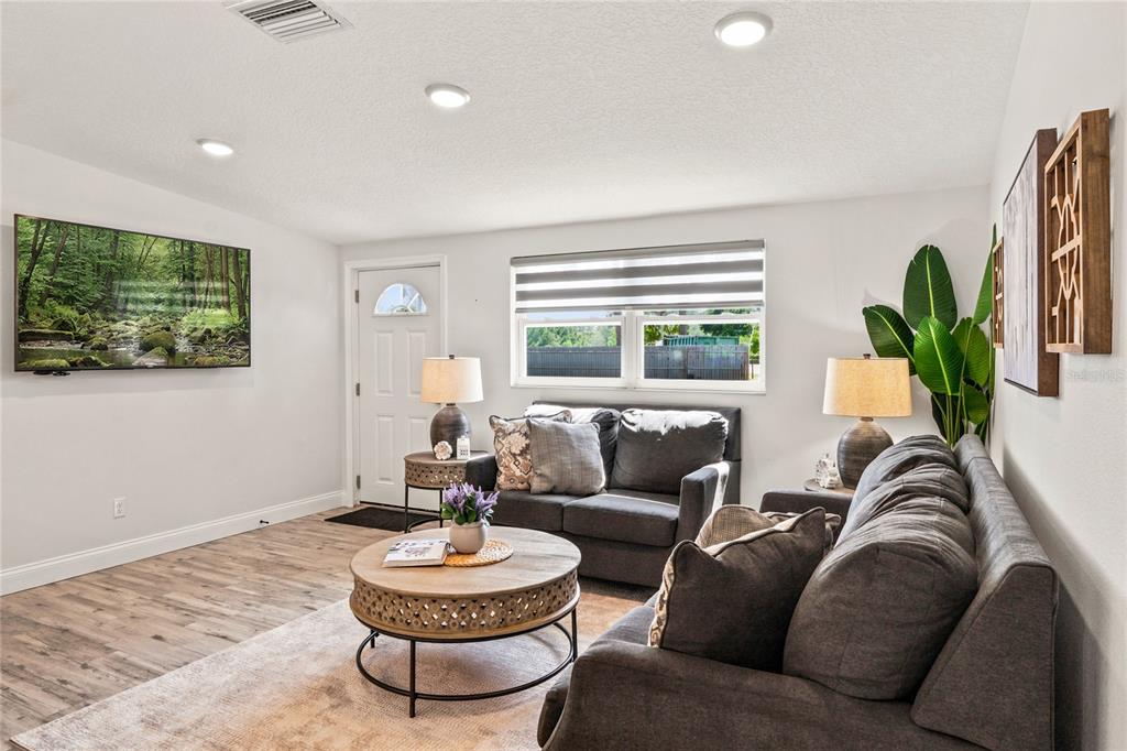 A single-story gray house with a white front door, garage, and dark window shutters — 749 N SR 415, OSTEEN, FL